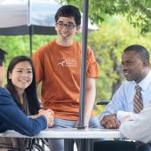 A group of McCombs students chat with each other outside of the school.