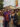 Eight people smile and pose for a photo together while attending the ODUNDE Festival in Philadelphia. Four wear straw hats and most wear colorful patterned clothing.