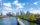 The Philadelphia skyline shines under a blue sky with white clouds. IN the foreground, the Schuylkill Banks Boardwalk juts out over the Schuylkill River