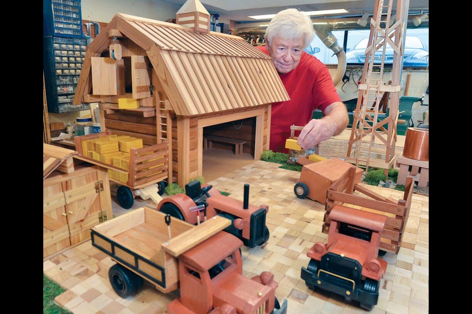 Silver Harbour Seniors Centre member Robert Proulx shares his wooden homestead in the centre's woodshop. It will be sold at Silver Harbour's annual Christmas market on Nov. 16. | Paul McGrath / North Shore News