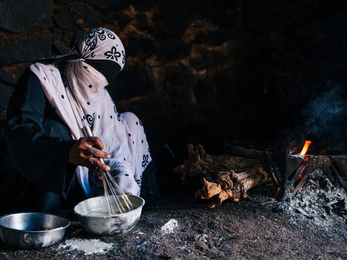 Woman stooped and preparing food in house