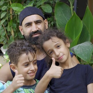 Ali, beneficiary of WFP assistance after the Beirut blast, with two of his children. Photo credit: WFP/Hasan Noureddine