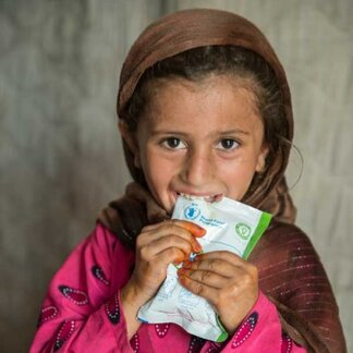 Child eating healthy and fortified snack provided by WFP