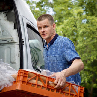 a man is carrying a box full of breads