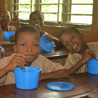 School children eating nutrient-rich meals distributed by WFP in Benin