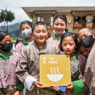 School children in Bhutan holding a card with Zero Hunger written on it