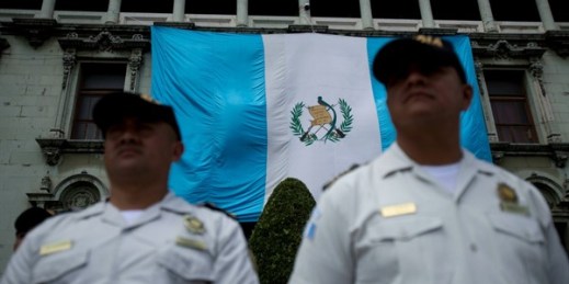 Police stand guard at the National Palace as protestors demonstrate against then-President Jimmy Morales and corruption in Guatemala City, Guatemala, Sept. 20, 2018 (AP photo by Moises Castillo).