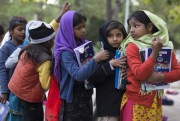 Girls from poor localities wait their turn to show school work to teacher, at a makeshift school in a city park in Islamabad, Pakistan, Nov. 13, 2018 (AP photo by B.K. Bangash).