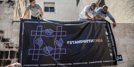 Activists hang a banner over the entrance to the al-Haq Human Rights Organization.